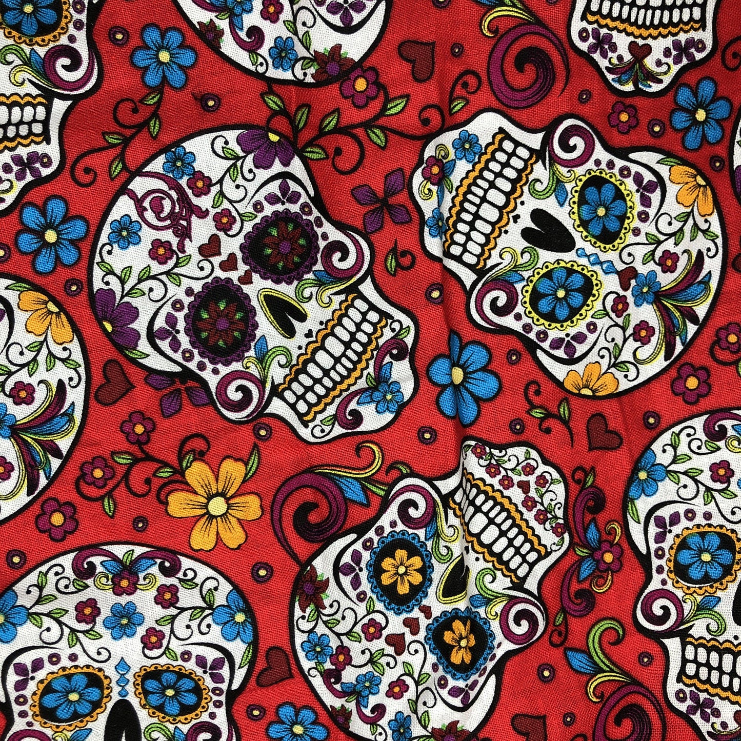 Bright colourful sugar skull pattern with a red background